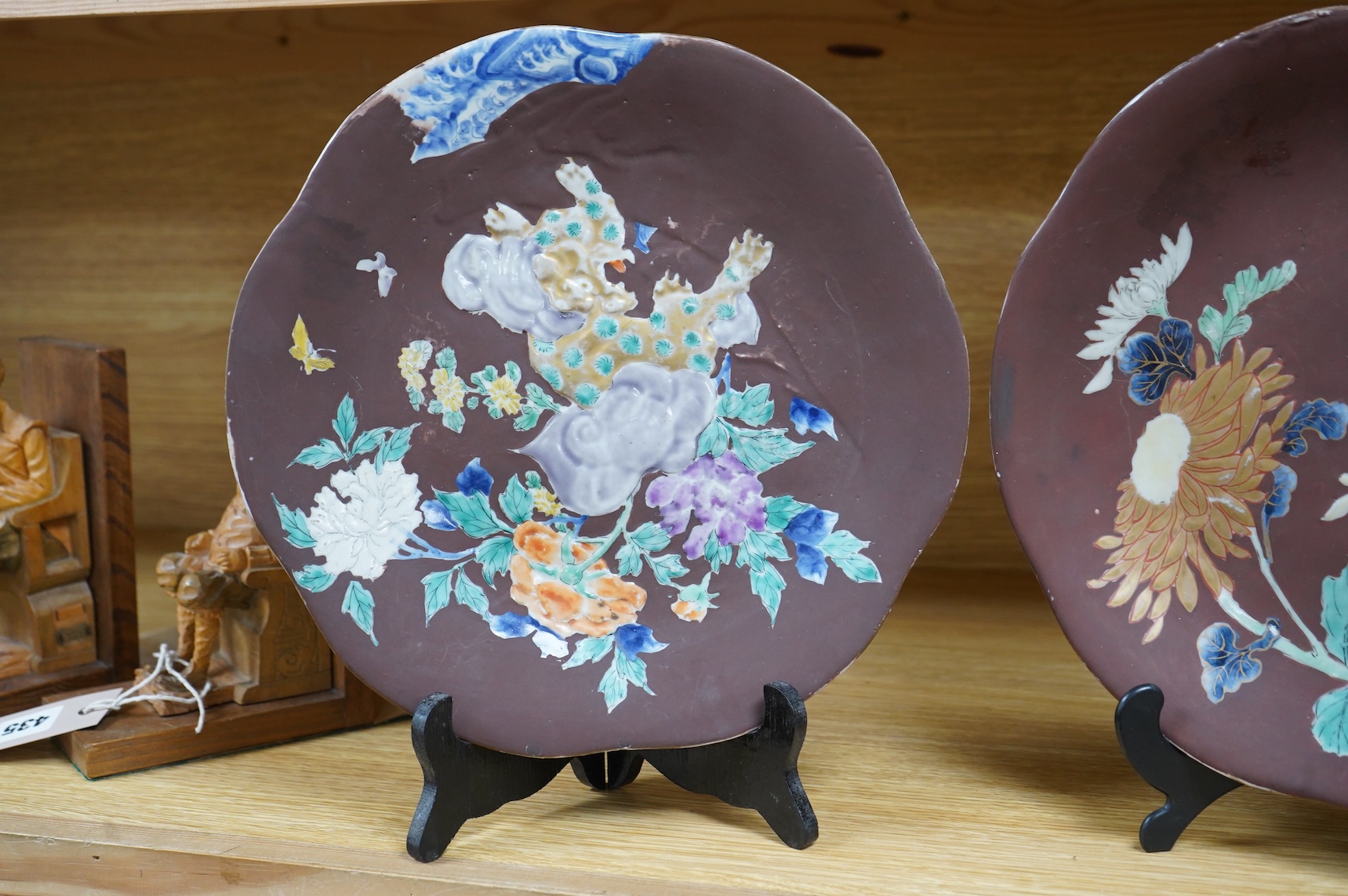A pair of Japanese relief plates with brown glaze, 28cm high